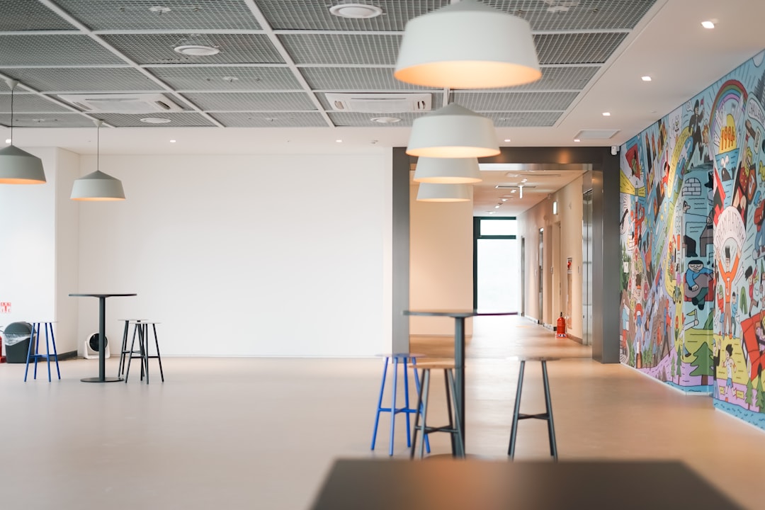 a-room-with-a-lot-of-stools-and-a-mural-on-the-wall-qjdxwrhaglu